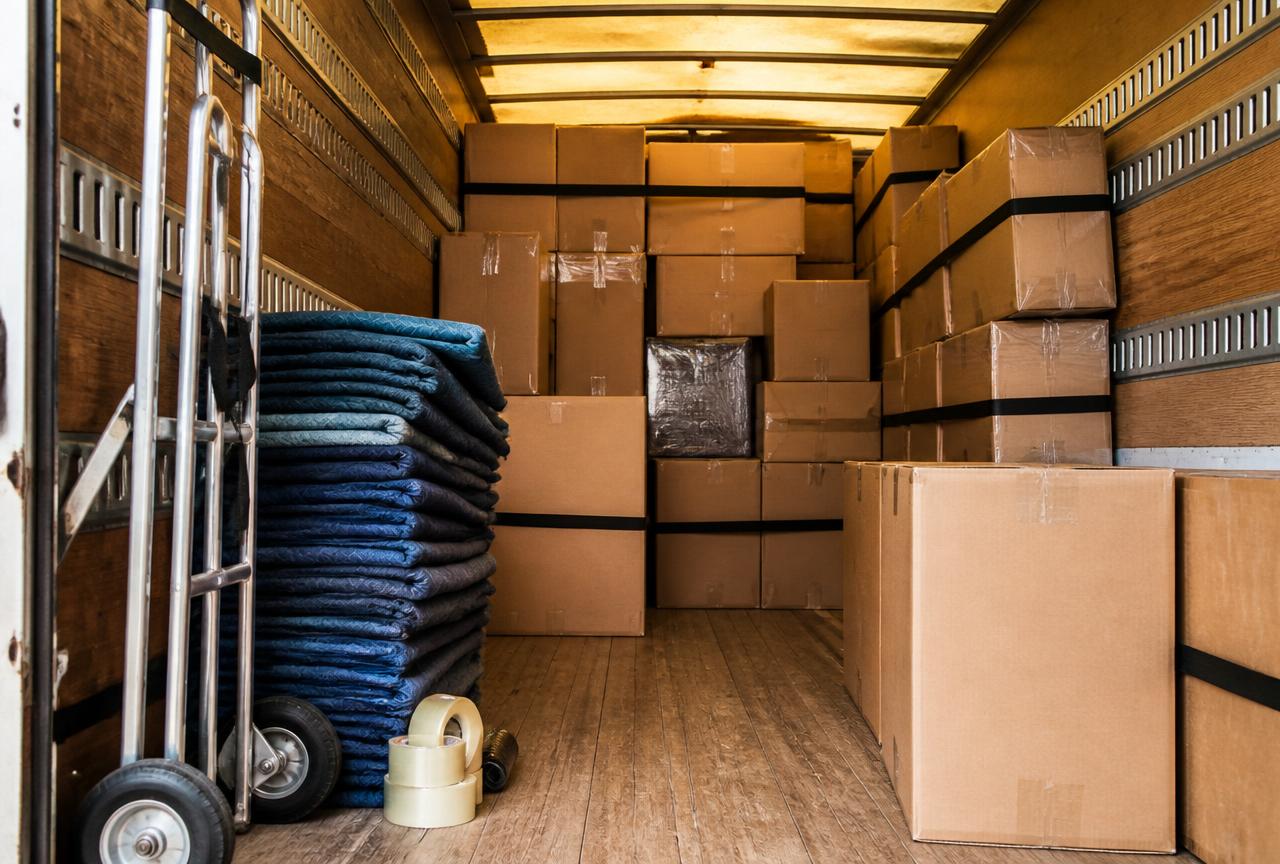 Organized interior of a moving truck with boxes and blankets